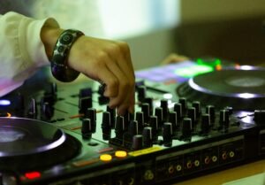 Close-up of a DJ mixing tracks on a console in a Tokyo nightclub, creating vibrant night vibes.