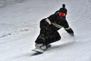 A skier in full gear carving through fresh snow on a winter slope, showcasing speed and skill.