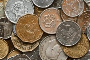 High-resolution close-up of various international coins featuring diverse symbols and textures.